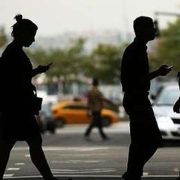 Multarán a los peatones que cruzan mirando el celular